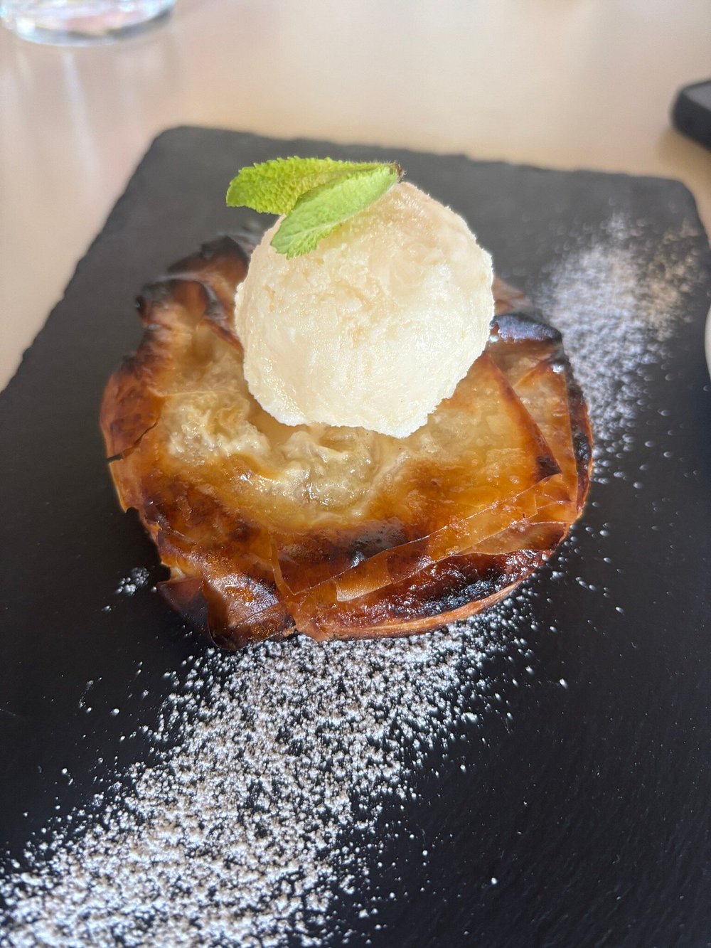 Tarta Tatin de manzana individual con una bola de helado encima.