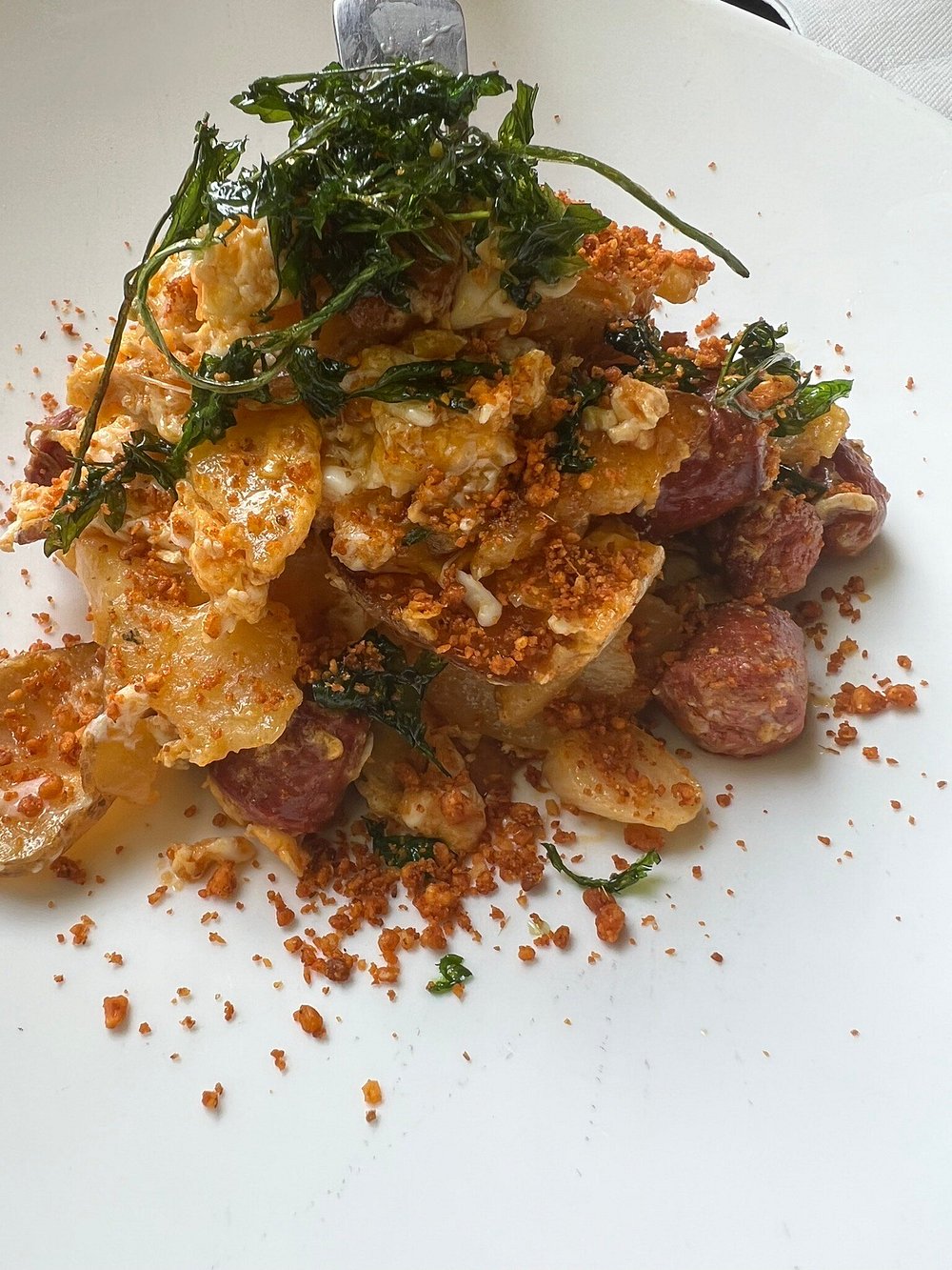 Plato de patatas panadera con huevo, chistorra troceada y pimentón.