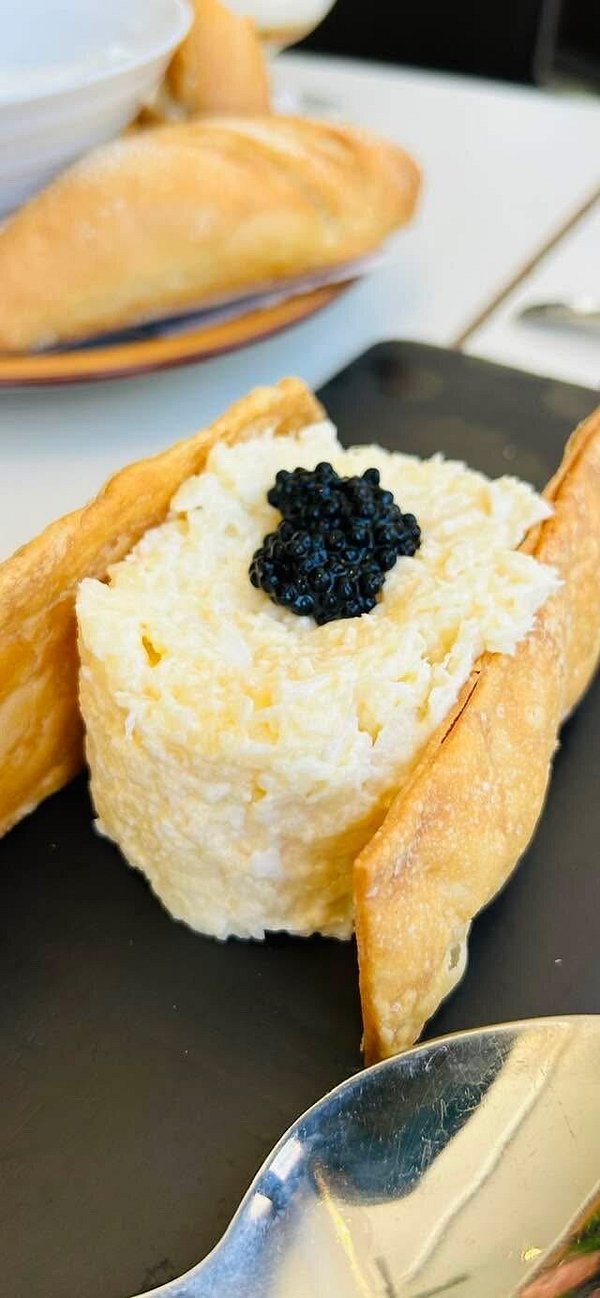 Tosta de pan con ensaladilla rusa y coronada con sucedáneo de caviar negro.